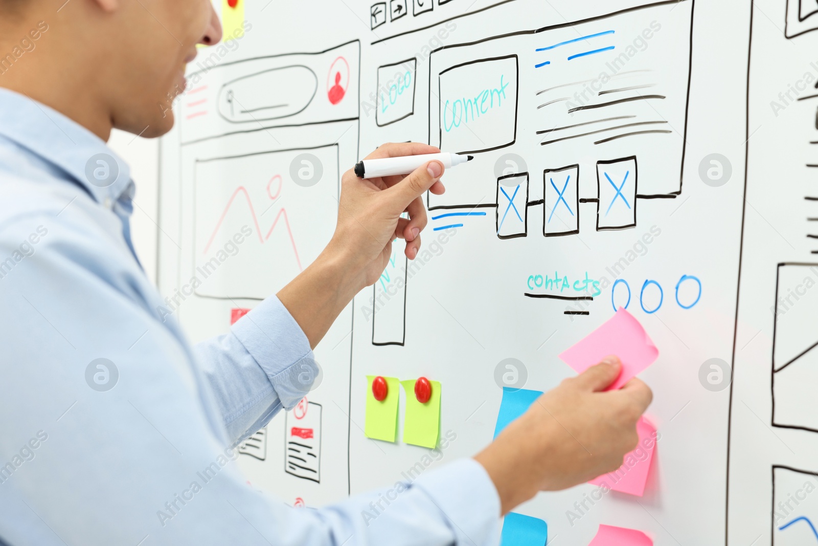 Photo of Developing UI design. Man drawing website wireframe on whiteboard indoors, closeup