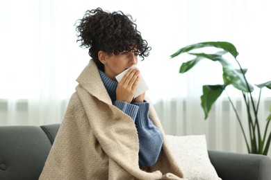 Photo of Cold symptom. Young woman with tissue at home