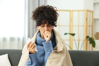 Photo of Cold symptom. Young woman with tissue at home