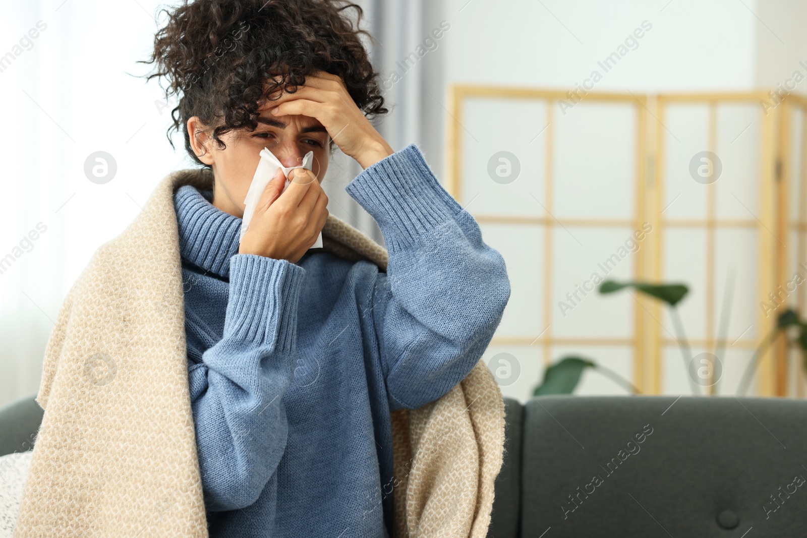 Photo of Cold symptom. Young woman with tissue at home, space for text