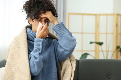 Photo of Cold symptom. Young woman with tissue at home, space for text