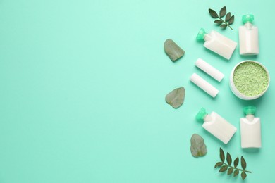 Photo of Different cosmetic products and leaves on turquoise background, flat lay. Space for text