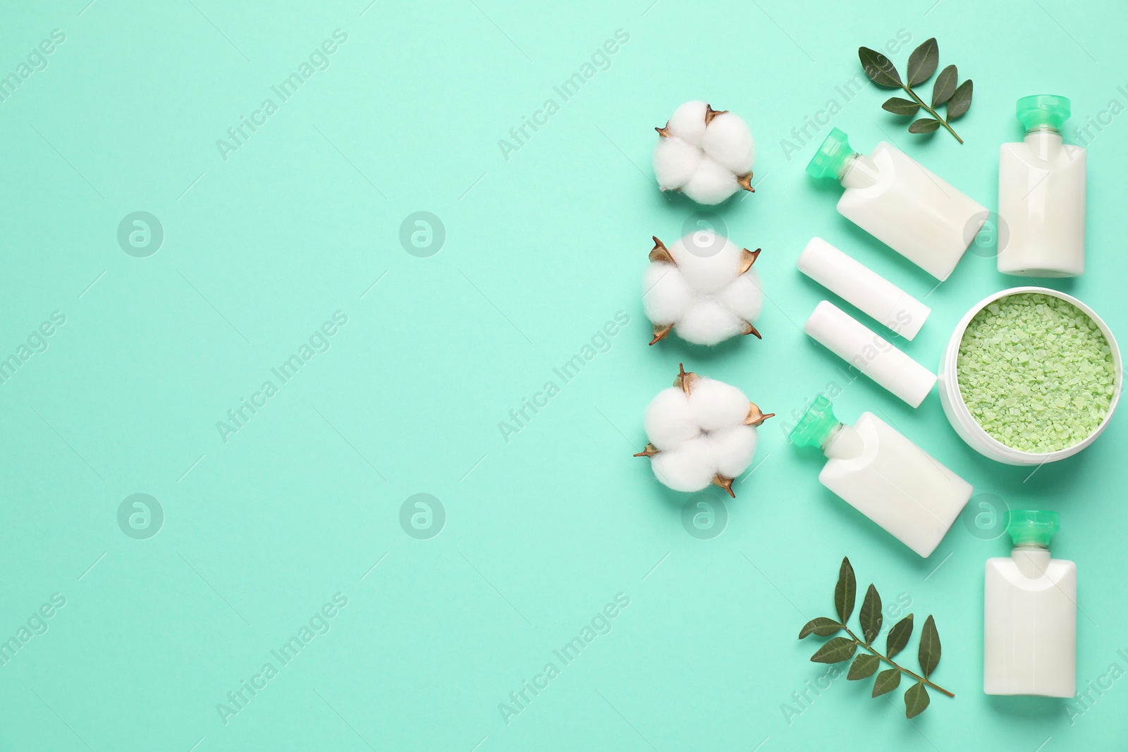 Photo of Different cosmetic products, leaves and cotton flowers on turquoise background, flat lay. Space for text