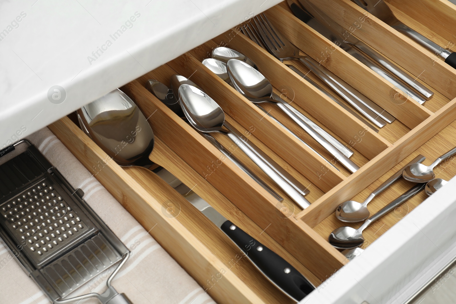 Photo of Box with cutlery in drawer, closeup. Kitchen utensils storage