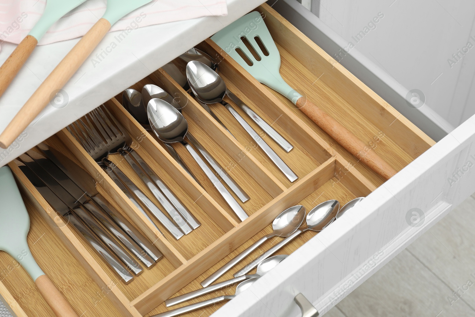 Photo of Box with cutlery in drawer, closeup. Kitchen utensils storage