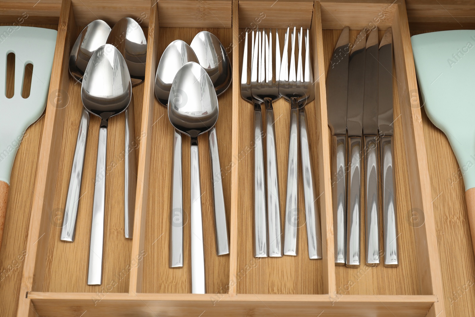 Photo of Box with cutlery in drawer, closeup. Kitchen utensils storage