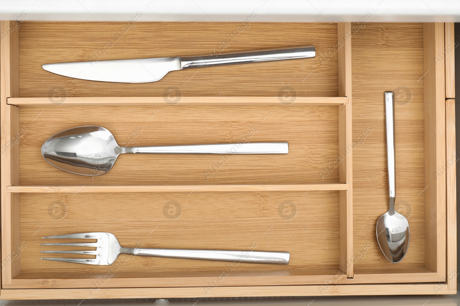 Photo of Box with cutlery in drawer, top view. Kitchen utensils storage