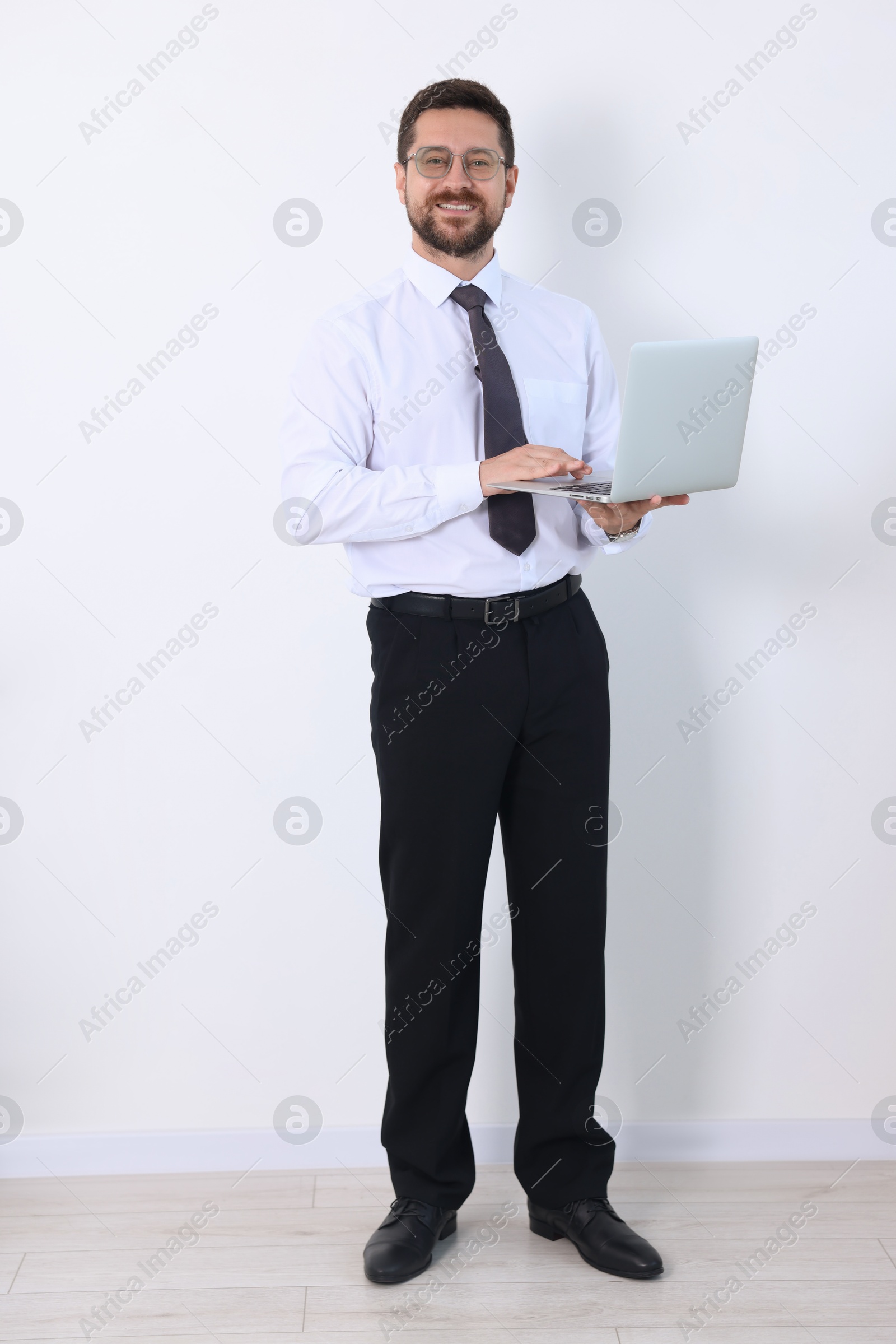 Photo of Smiling businessman with laptop on white background