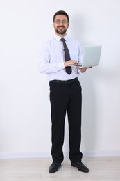 Photo of Smiling businessman with laptop on white background