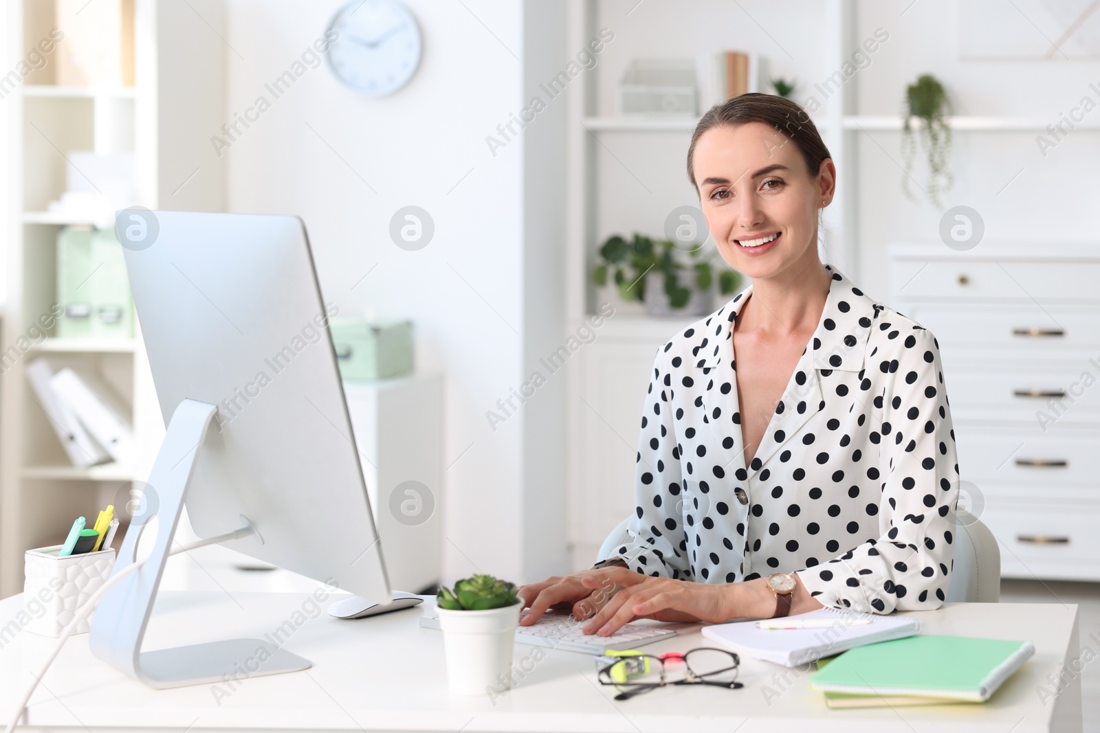 Photo of Smiling businesswoman working at table in office