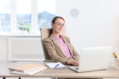 Photo of Smiling businesswoman working at table in office