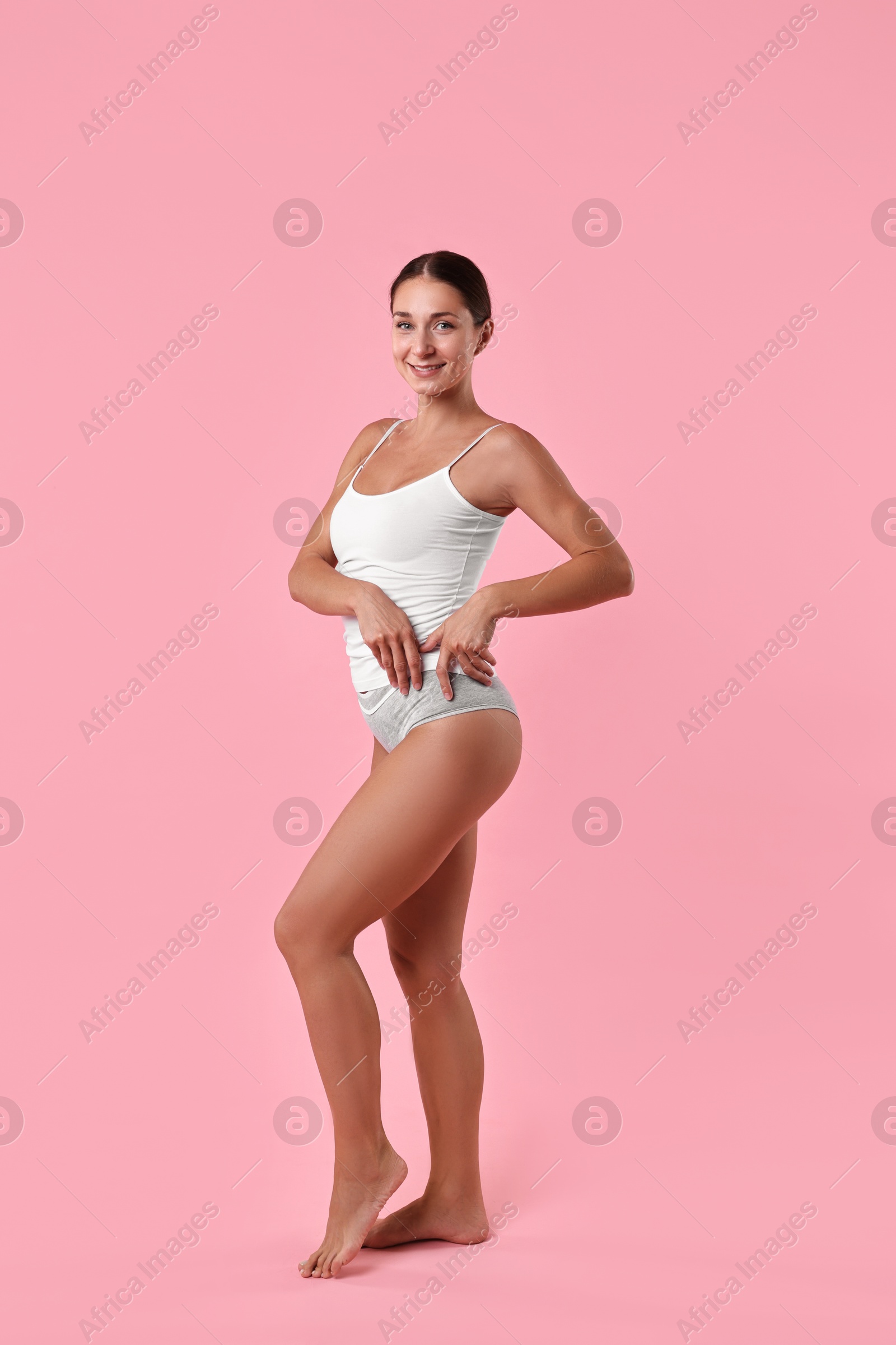 Photo of Smiling woman with perfect skin on pink background. Body care