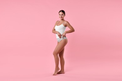 Photo of Smiling woman with perfect skin on pink background. Body care