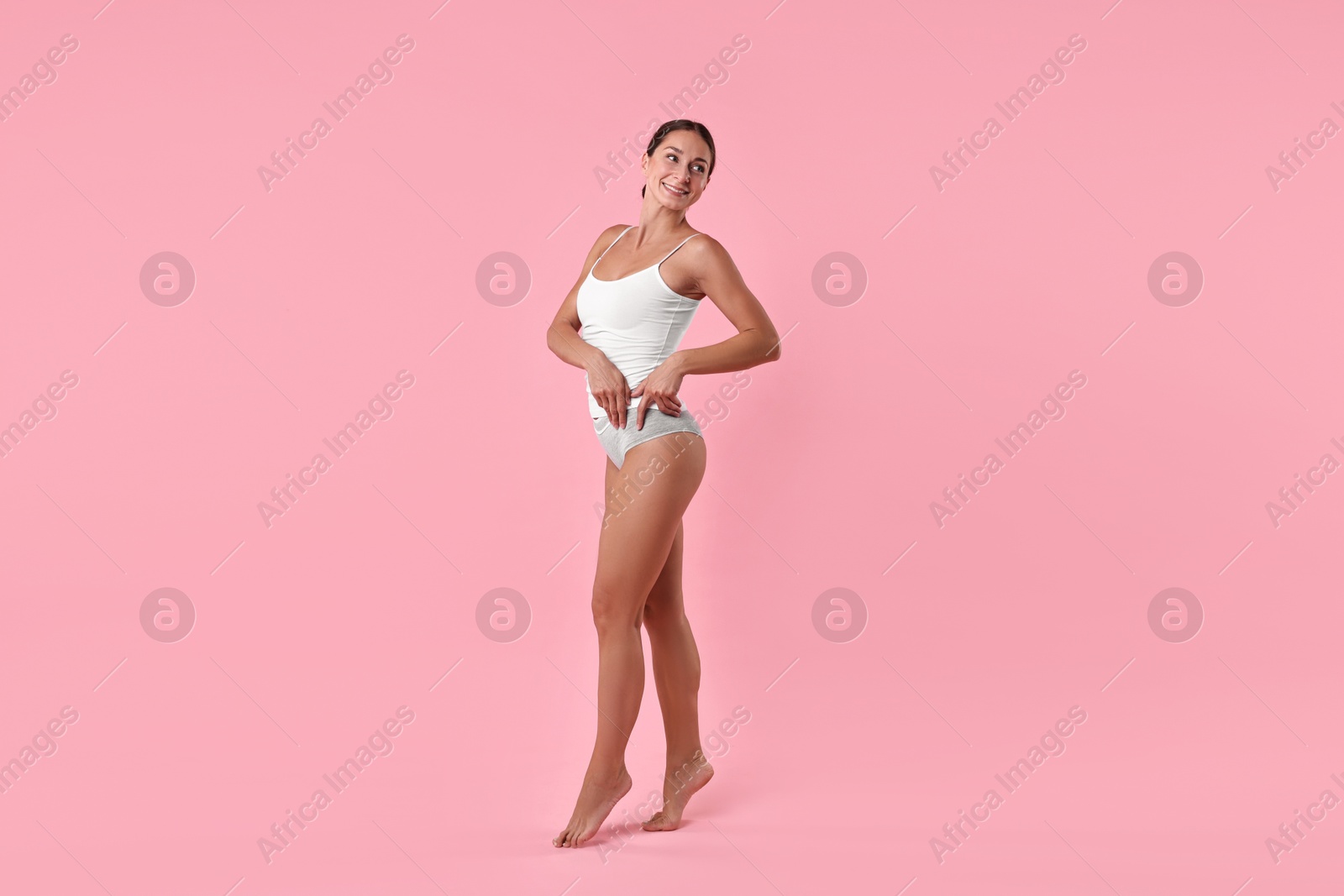 Photo of Smiling woman with perfect skin on pink background. Body care