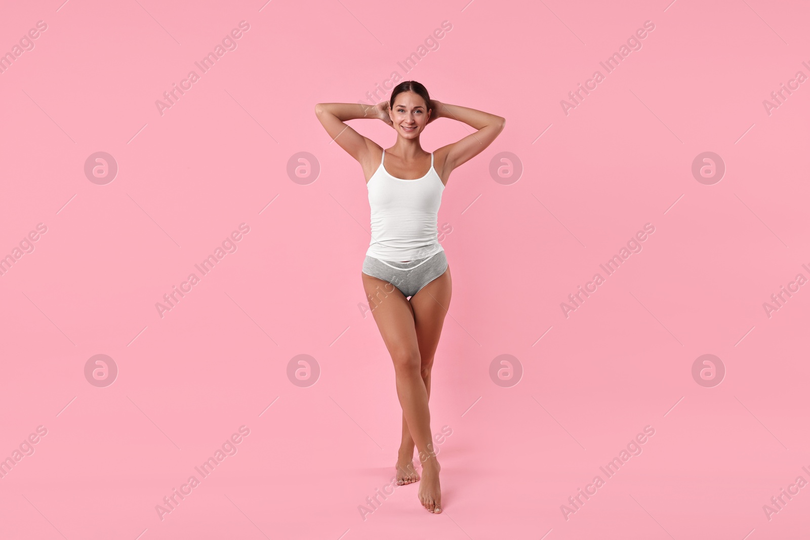 Photo of Smiling woman with perfect skin on pink background. Body care