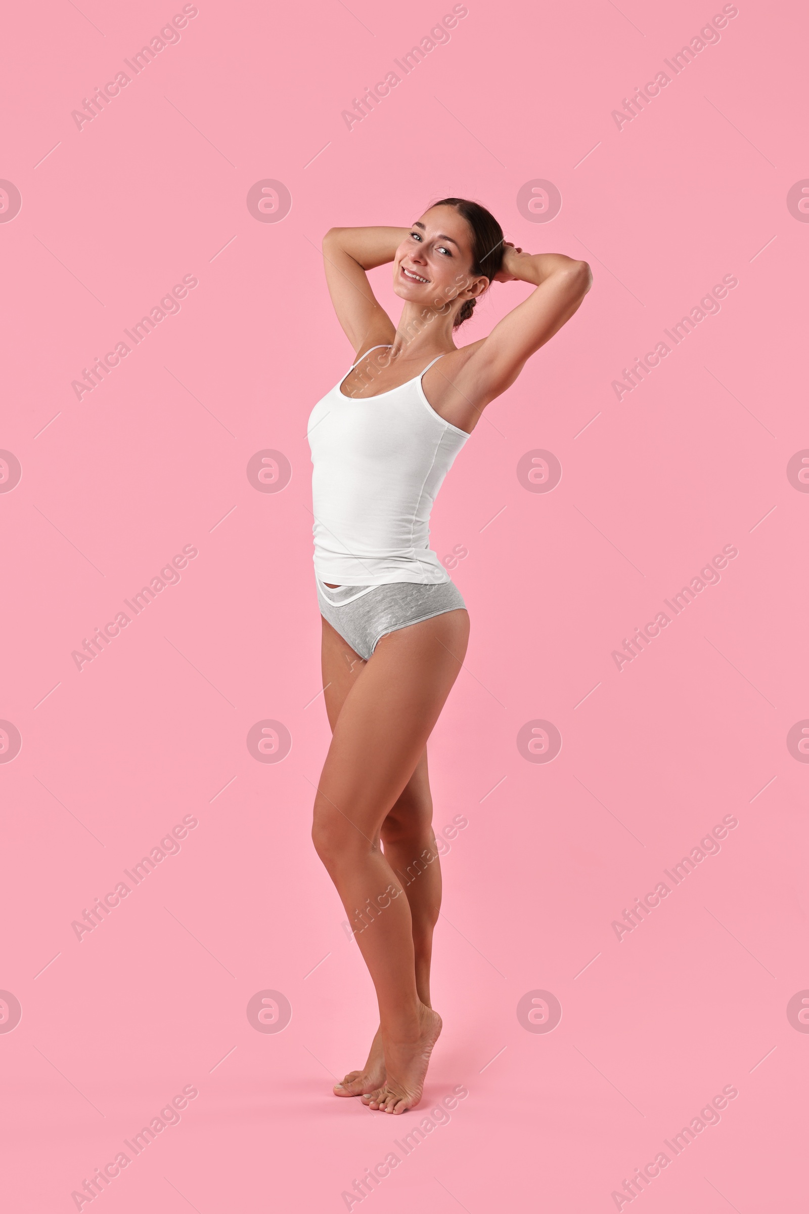 Photo of Smiling woman with perfect skin on pink background. Body care