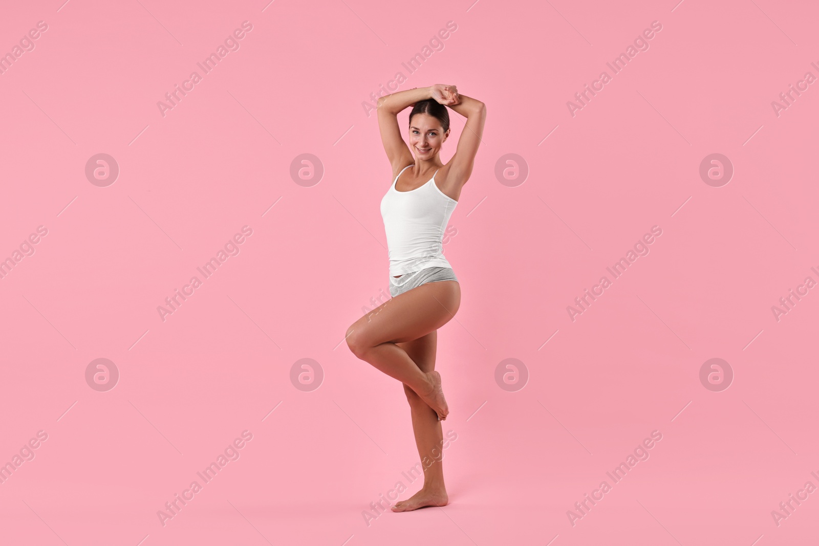 Photo of Smiling woman with perfect skin on pink background. Body care