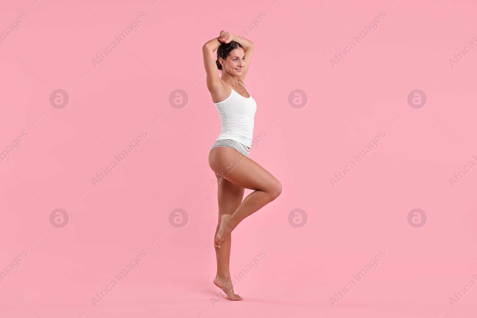 Photo of Smiling woman with perfect skin on pink background. Body care