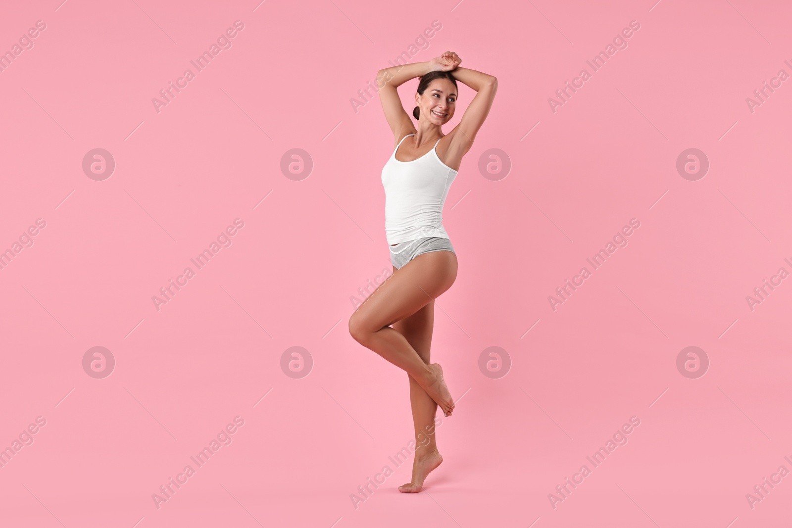 Photo of Smiling woman with perfect skin on pink background. Body care