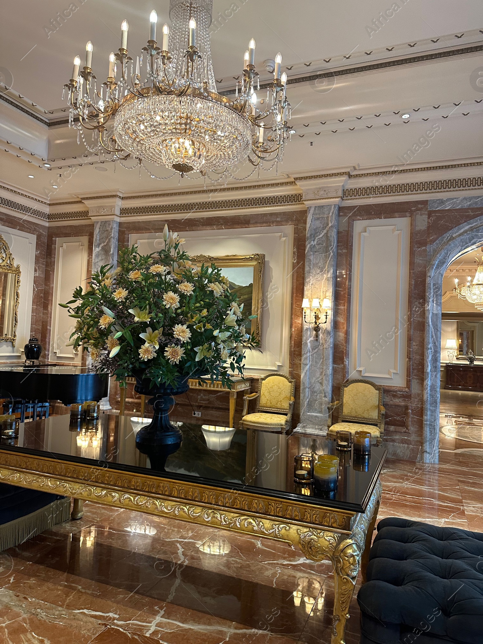 Photo of Vase with beautiful lilies and dahlias on mirrored table in hall of luxury hotel