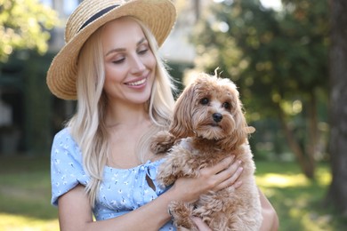 Beautiful young woman with cute dog in park