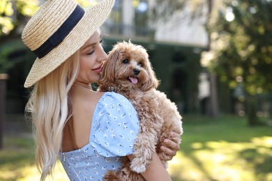 Beautiful young woman with cute dog in park