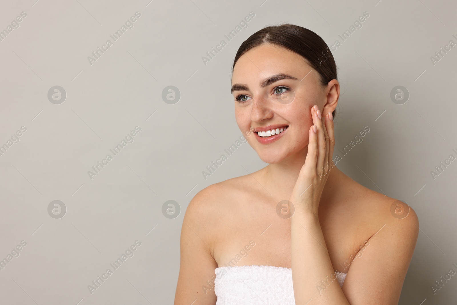 Photo of Beautiful young woman with healthy skin on grey background