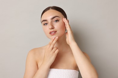 Photo of Beautiful young woman with healthy skin on grey background