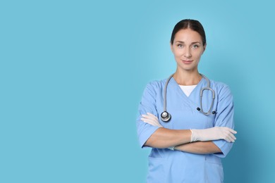 Photo of Nurse in medical uniform with stethoscope on light blue background, space for text