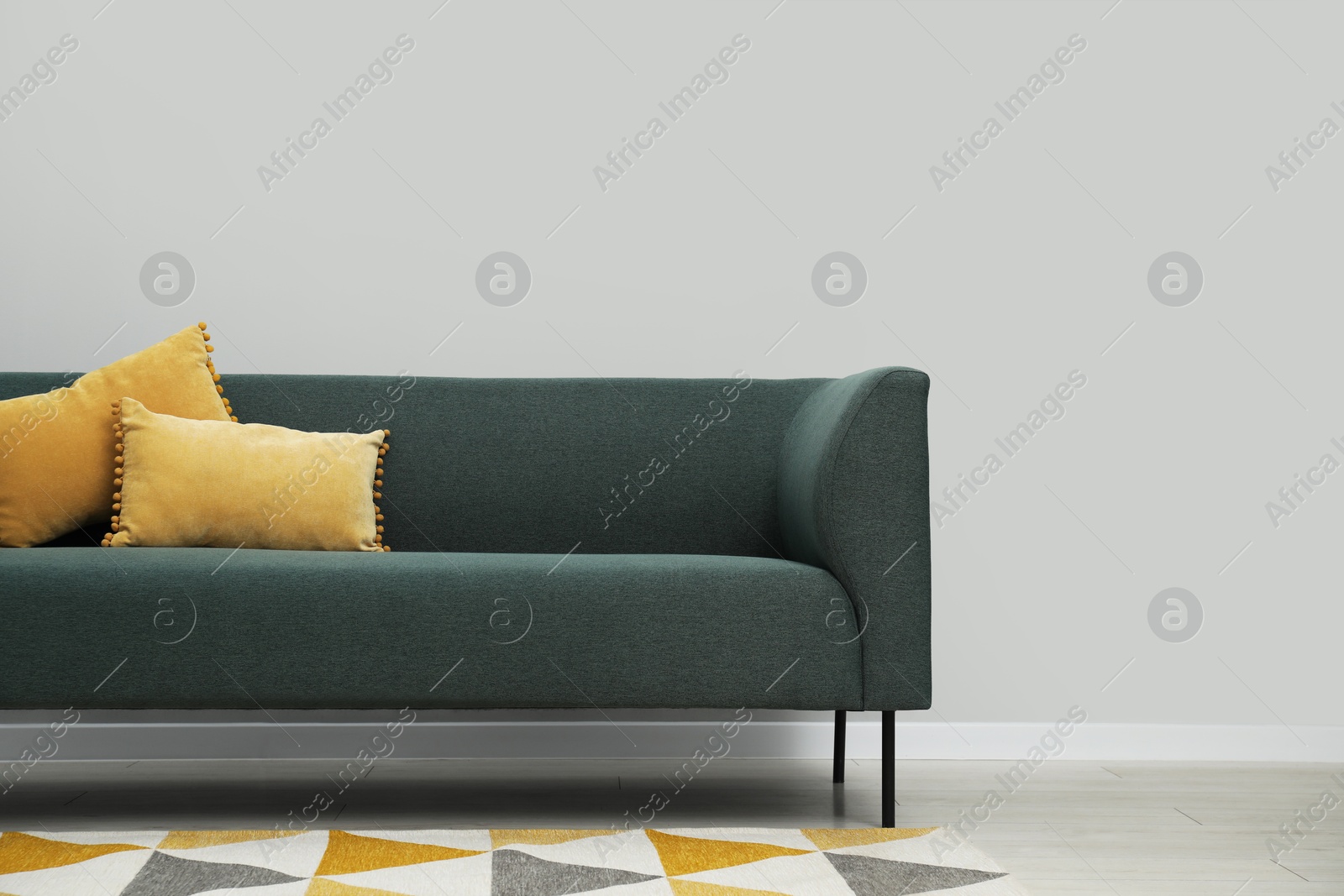 Photo of Comfortable sofa near light grey wall indoors