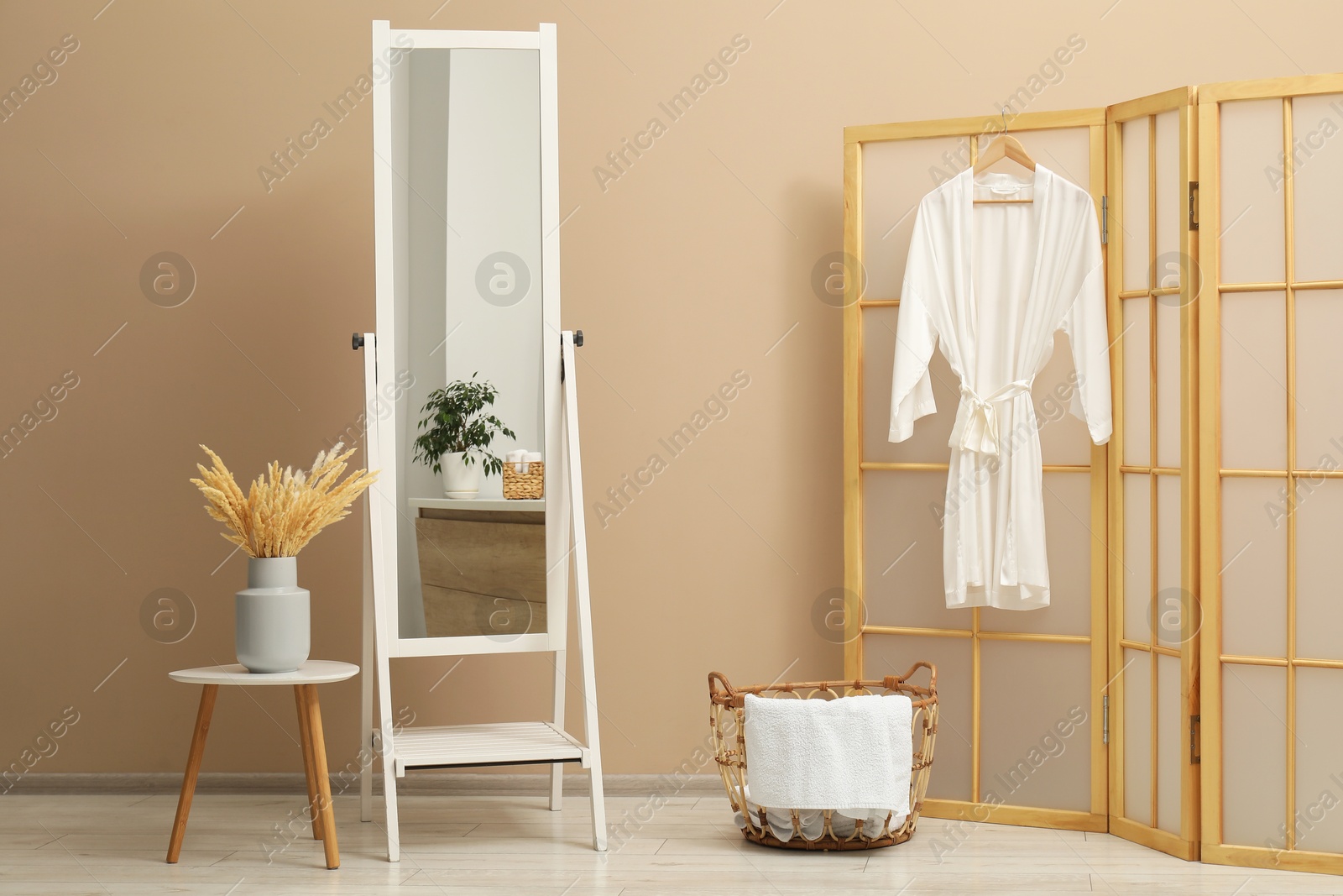 Photo of Large mirror near beige wall in bathroom. Interior design