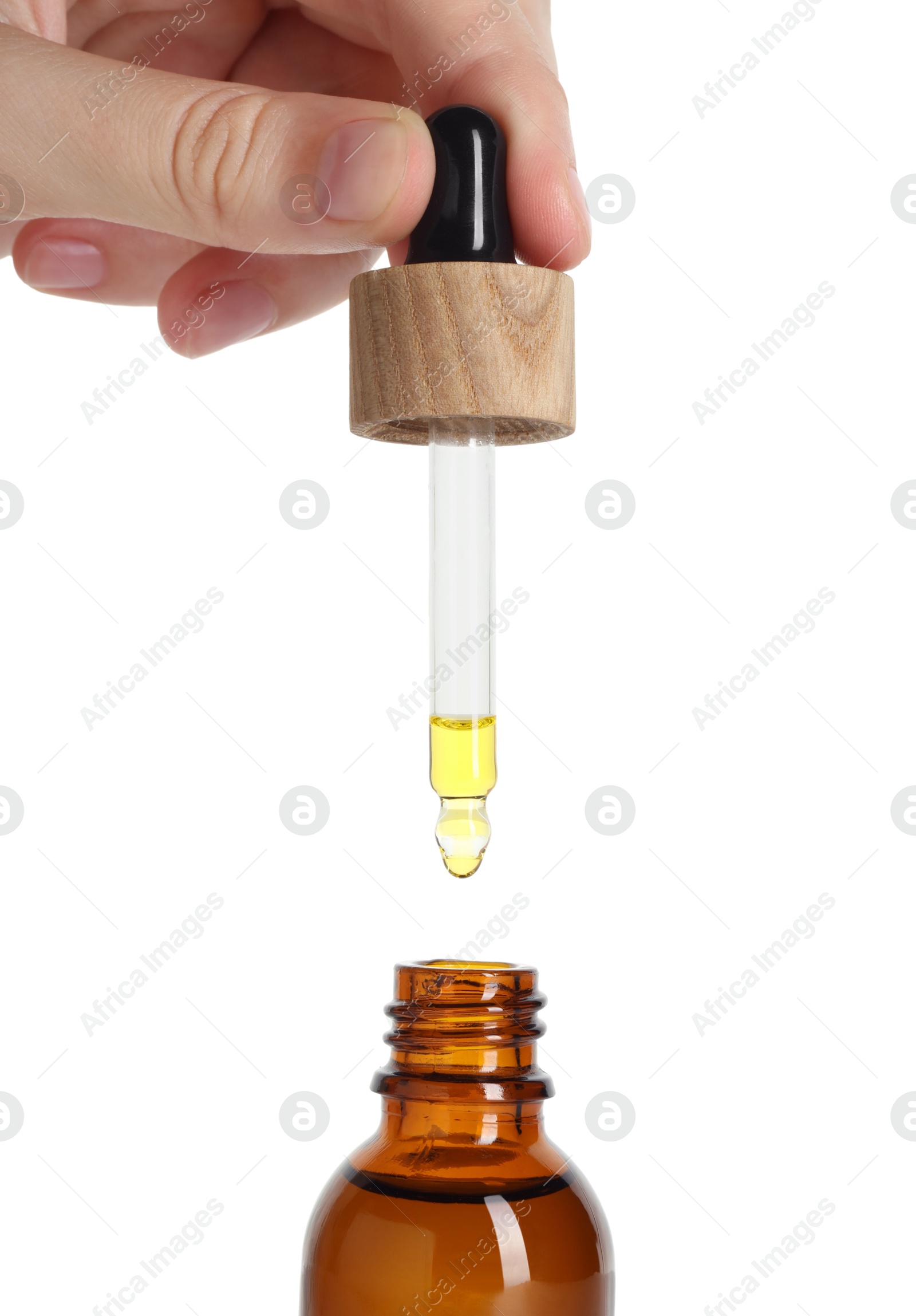 Photo of Woman dripping tincture from pipette into bottle on white background, closeup