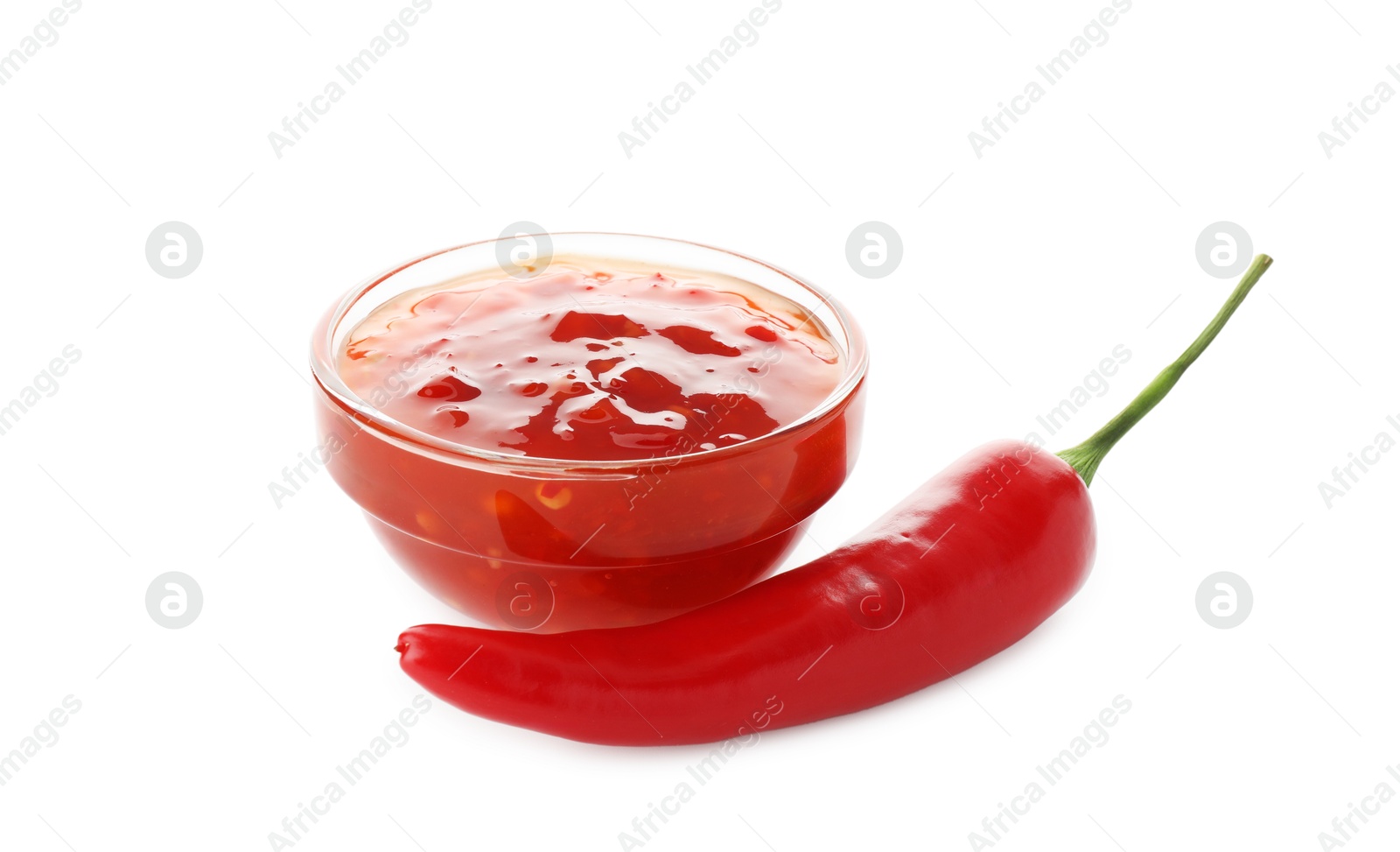 Photo of Hot chili sauce in bowl and pepper isolated on white