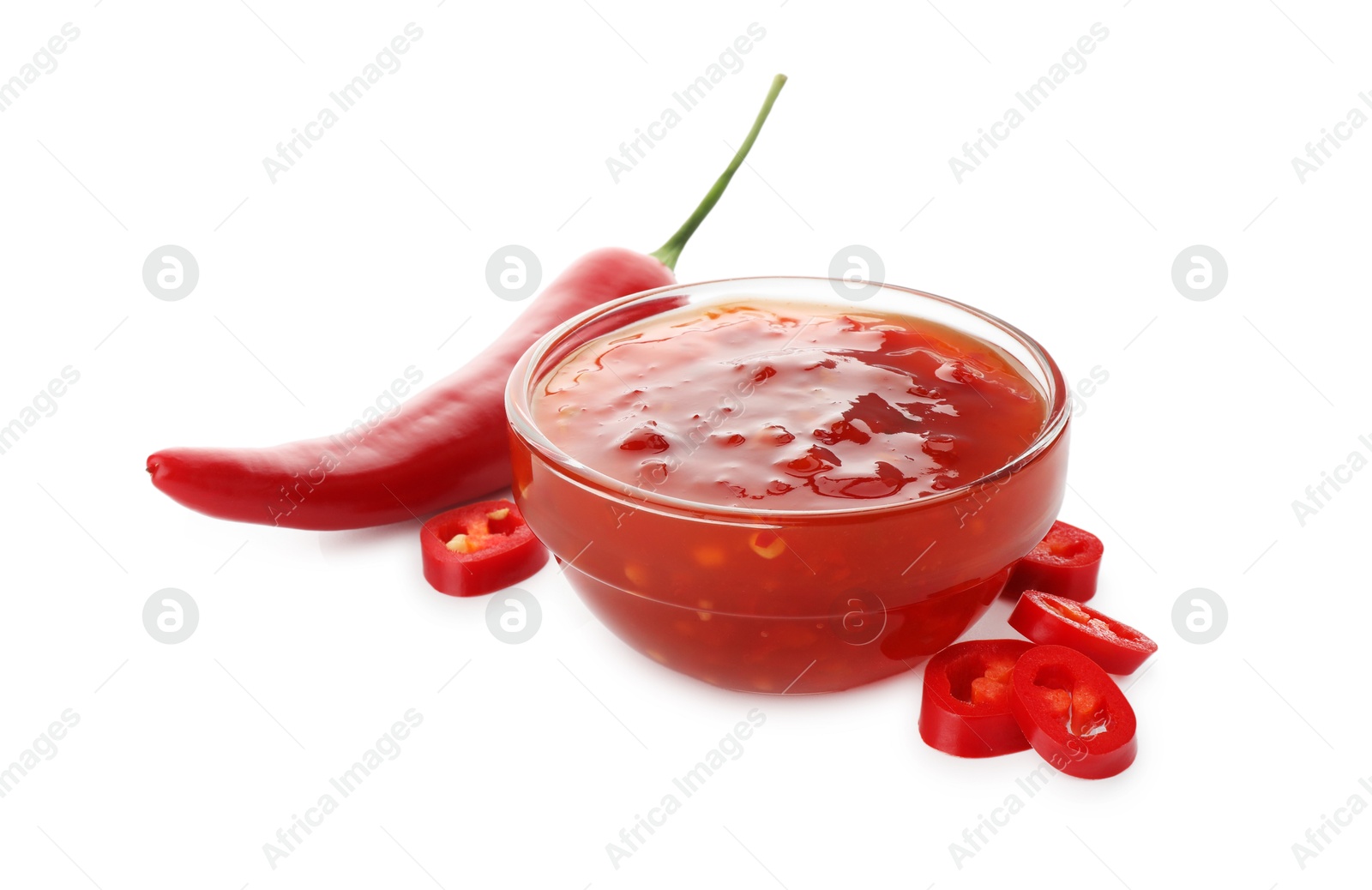 Photo of Hot chili sauce in bowl and pepper isolated on white