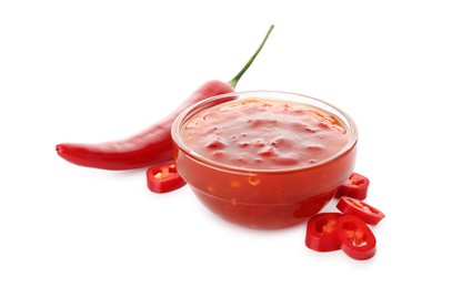 Photo of Hot chili sauce in bowl and pepper isolated on white