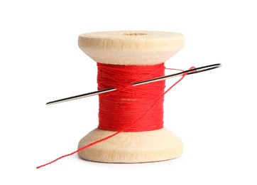 Photo of Spool of red sewing thread with needle isolated on white