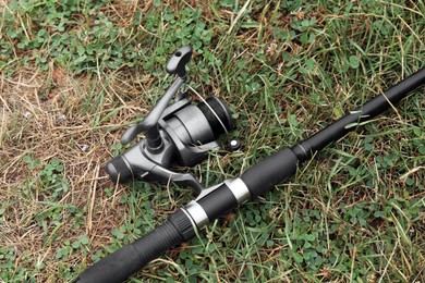 One fishing rod on green grass, above view