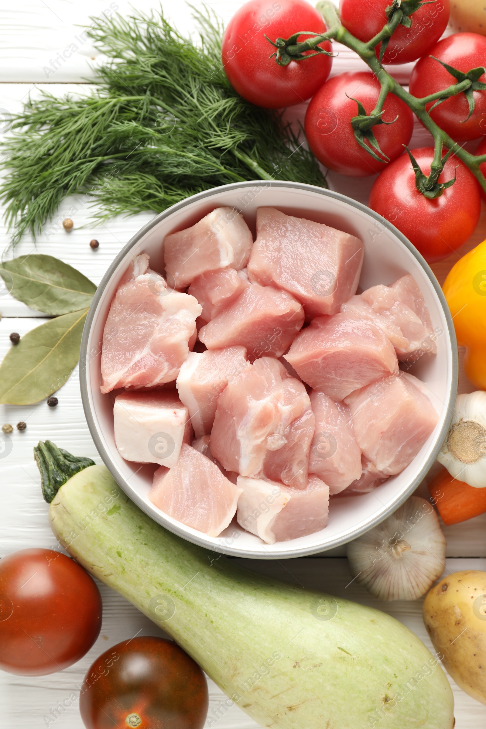 Photo of Uncooked ingredients for stew on white wooden table, flat lay