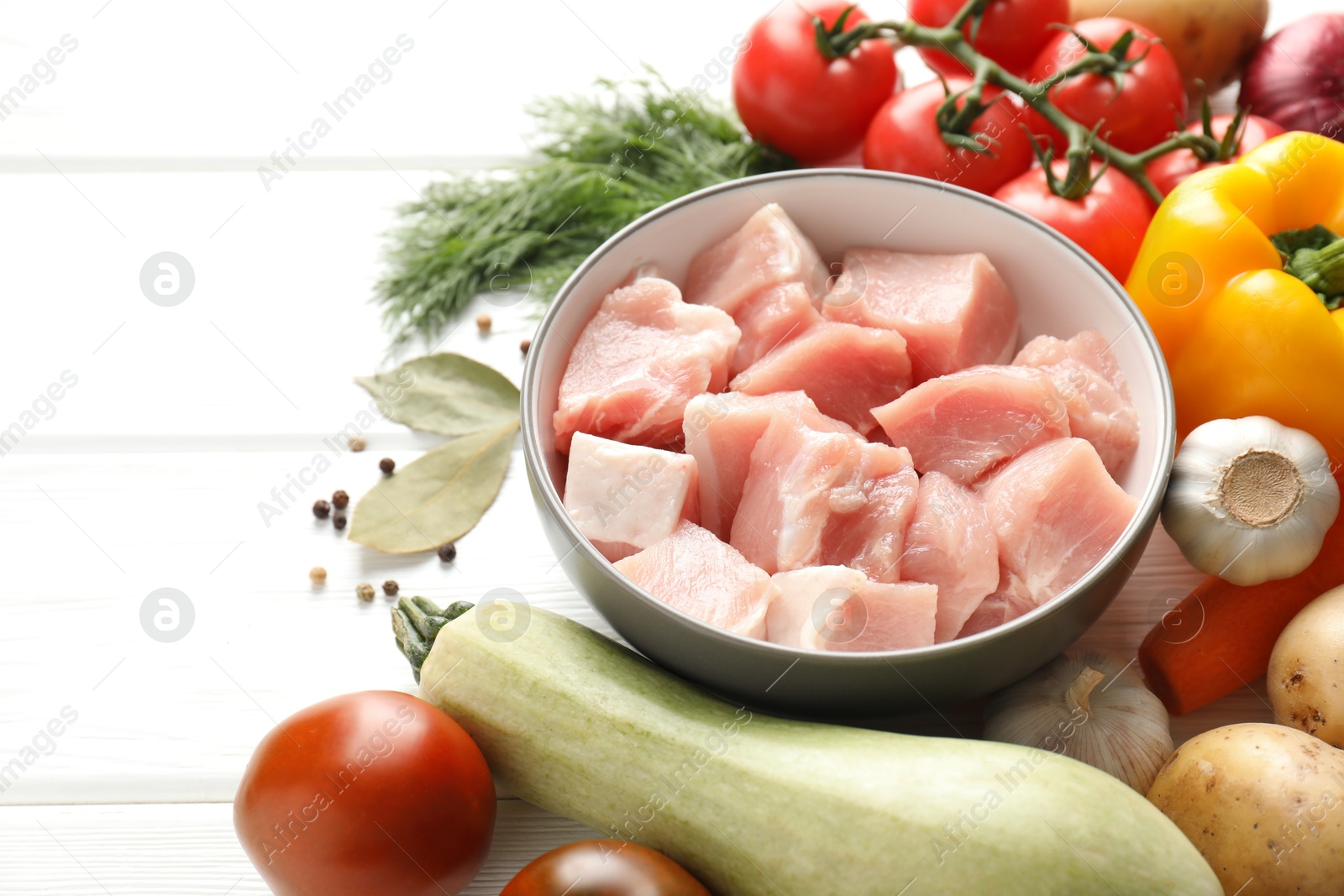 Photo of Uncooked ingredients for stew on white wooden table, closeup