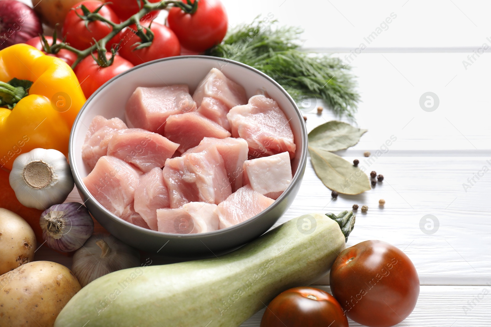 Photo of Uncooked ingredients for stew on white wooden table, closeup