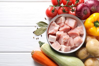 Photo of Uncooked ingredients for stew on white wooden table, flat lay. Space for text