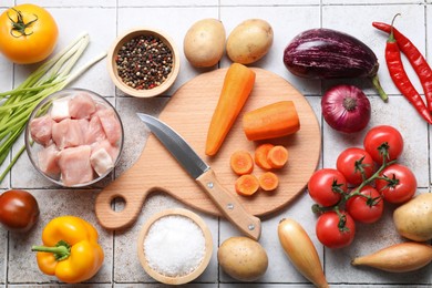 Photo of Uncooked ingredients for stew on tiled table, flat lay