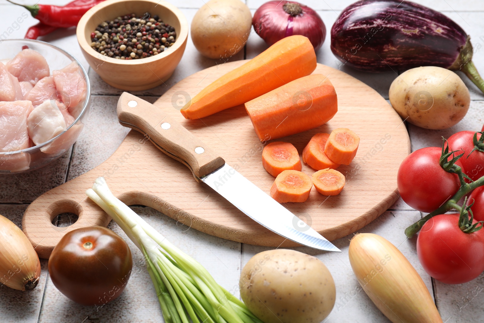 Photo of Uncooked ingredients for stew on tiled table, closeup