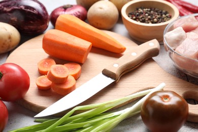 Photo of Uncooked ingredients for stew on white table, closeup