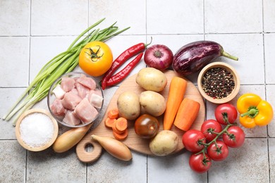 Photo of Uncooked ingredients for stew on tiled table, flat lay