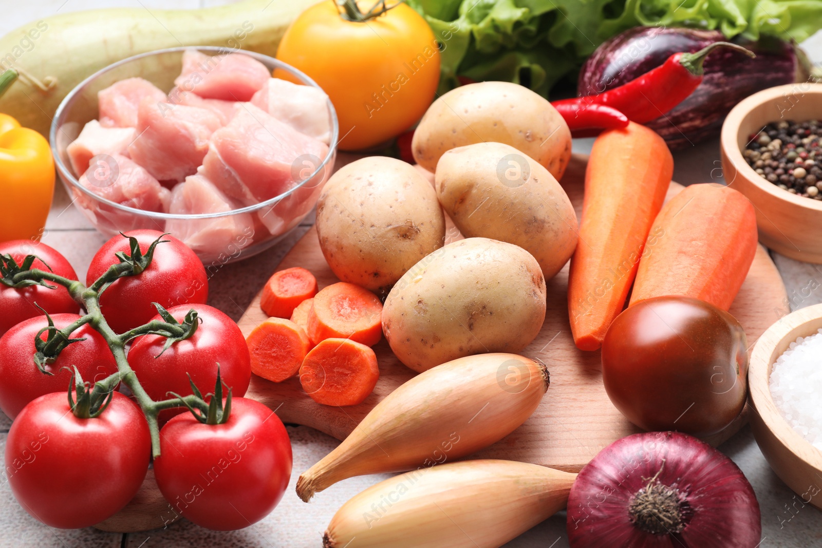 Photo of Uncooked ingredients for stew on tiled table, closeup