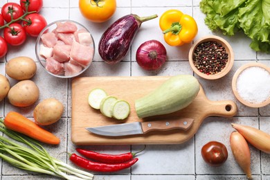 Photo of Uncooked ingredients for stew on tiled table, flat lay