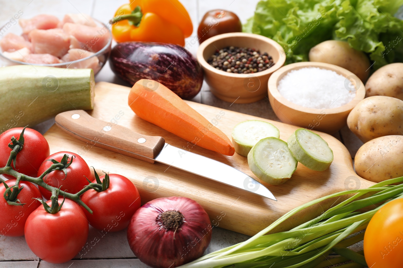 Photo of Uncooked ingredients for stew on tiled table, closeup