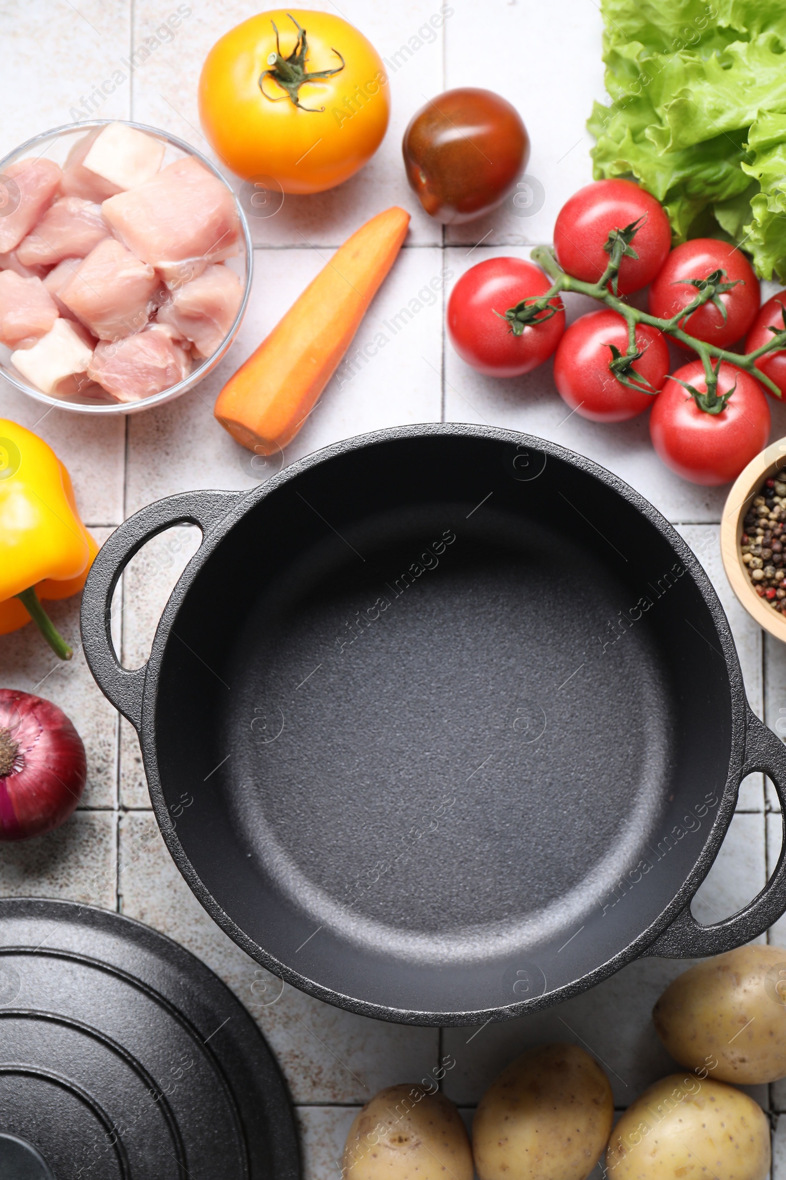 Photo of Uncooked ingredients for stew on tiled table, flat lay