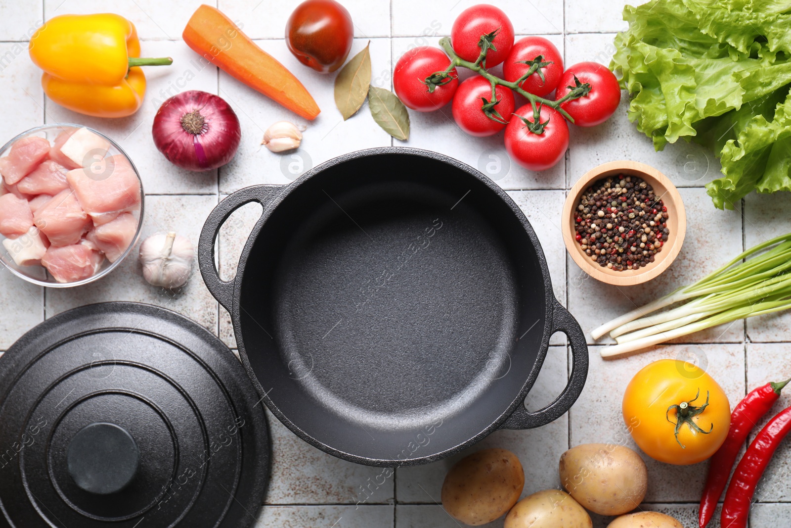 Photo of Uncooked ingredients for stew on tiled table, flat lay